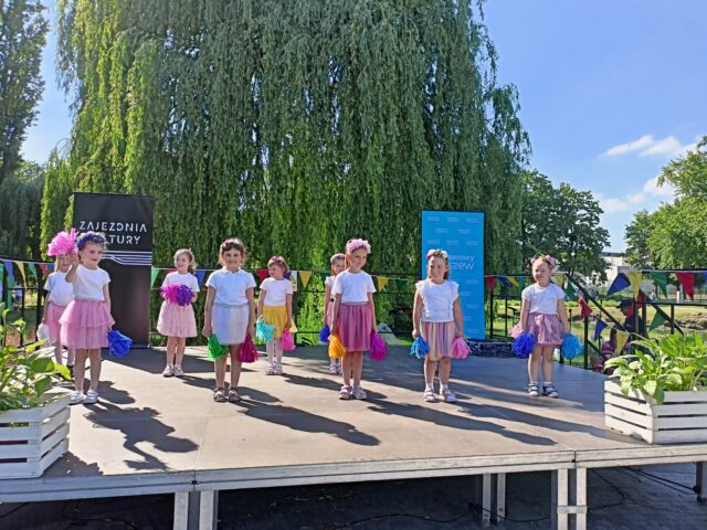 dzieci w kolorowych spódniczkach występujące na scenie