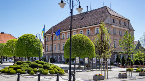 na zdjęciu znajduje się Ratusz - siedziba Urzędu Miasta i Gminy w Pleszewie wśród otaczającej go zieleni
