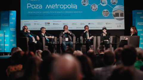 Uczestnicy debaty siedzący na scenie w Zajezdni Kultury w Pleszewie podczas konferencji Poza metropolią