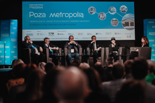 Uczestnicy debaty siedzący na scenie w Zajezdni Kultury w Pleszewie podczas konferencji Poza metropolią