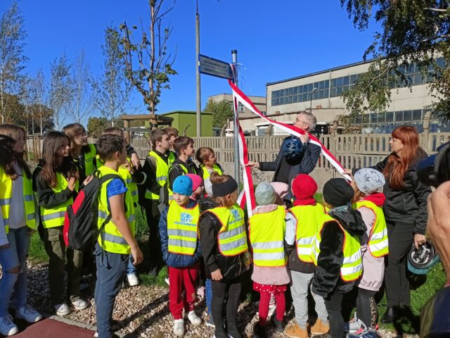 dzieci i młodzież w odblaskowych kamizelkach oraz burmistrz oraz dziennikarka Rzeczpospolitej otwierają Trakt Światowego Dnia Roweru w Pleszewie