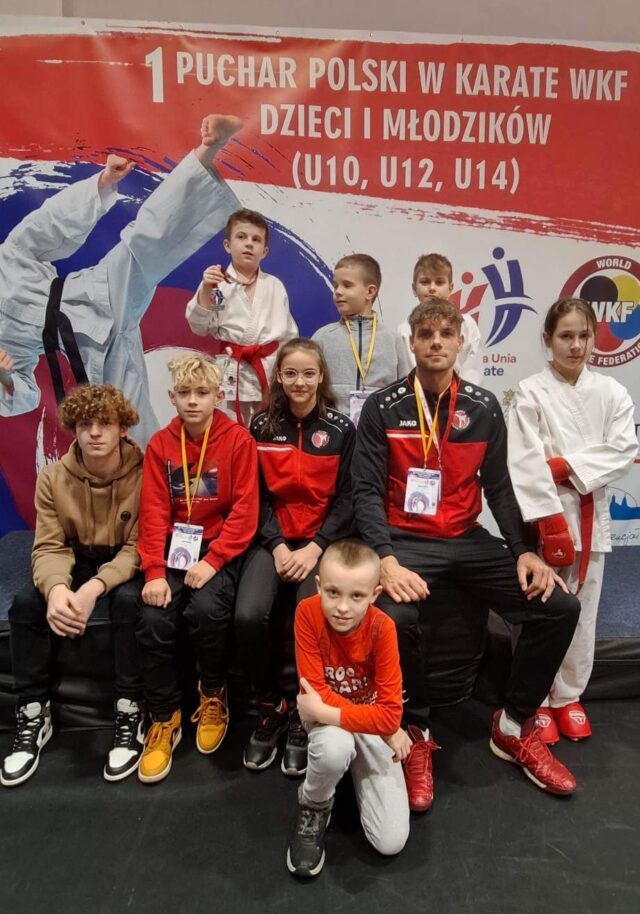 Zdjęcie przedstawia zawodników Pleszewskiego Klubu Karate wraz z trenerem biorących udział w 1. Pucharze Polski Dzieci i Młodzików w Karate