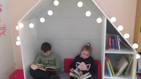 Uczniowie czytający książki w nowej strefie relaksu w pleszewskiej szkole.