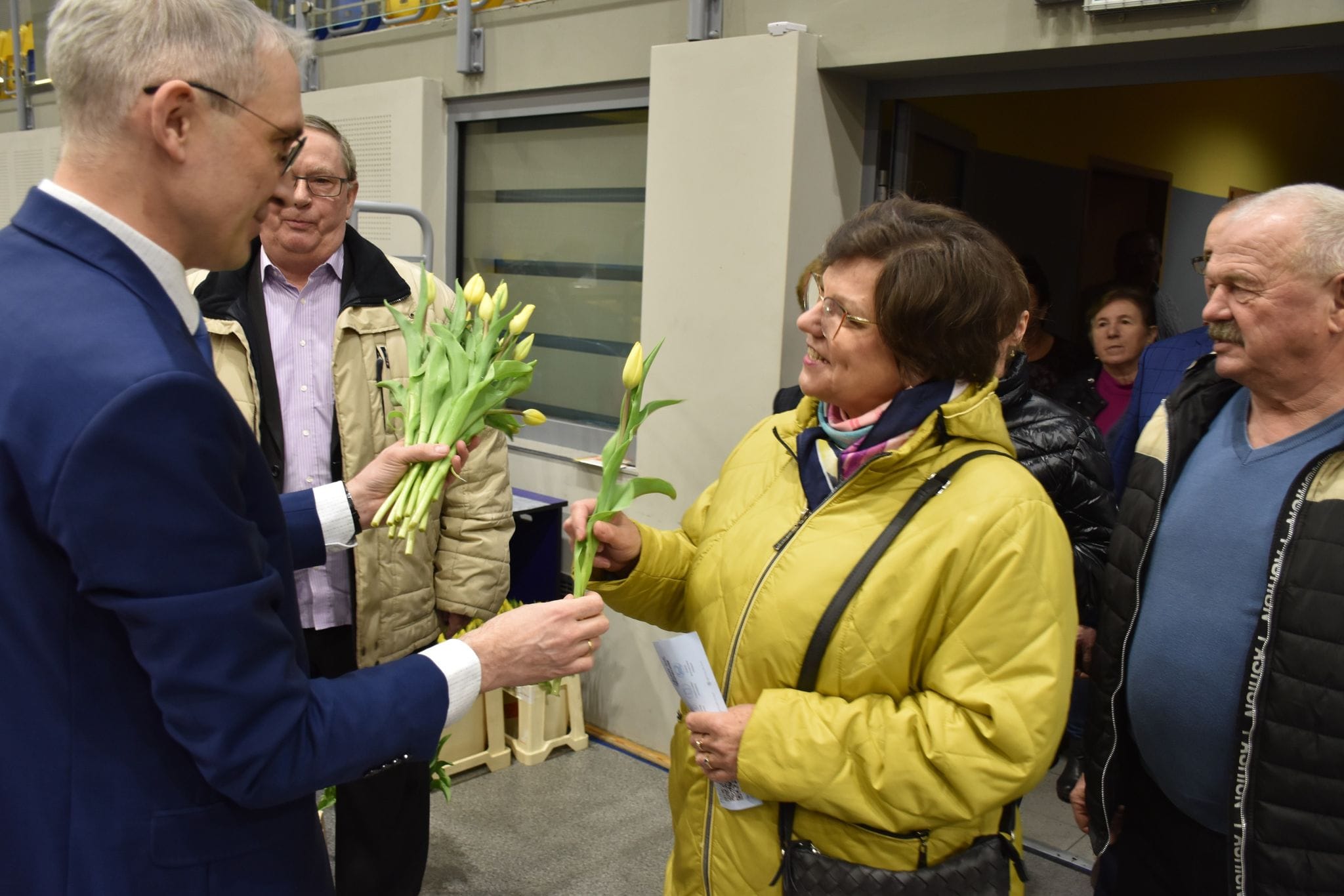 Burmistrz wręczający kwiaty na koncercie z okazji Dnia Kobiet na hali widowiskowo-sportowej w Pleszewie.