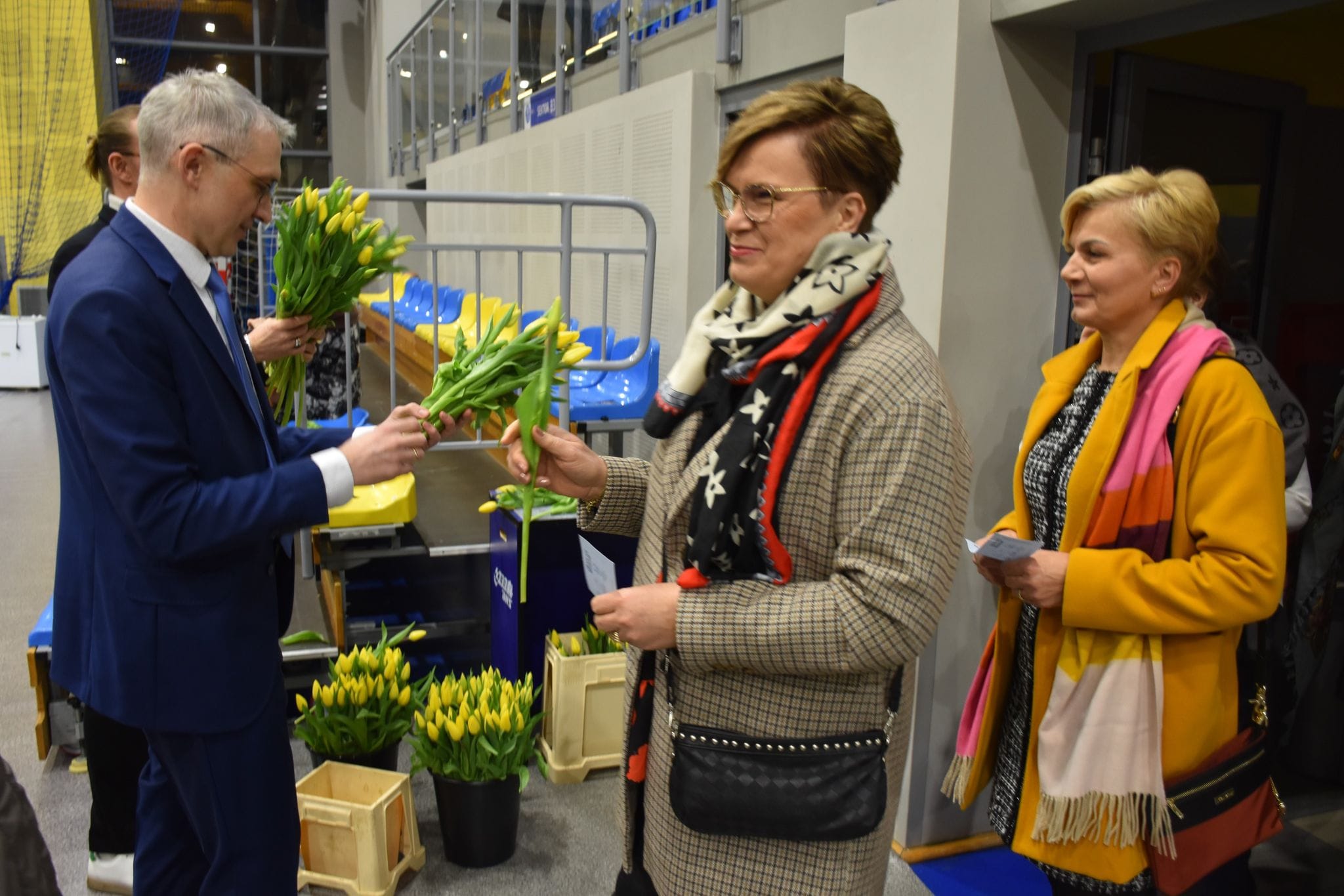 Burmistrz wręczający kwiaty na koncercie z okazji Dnia Kobiet na hali widowiskowo-sportowej w Pleszewie.