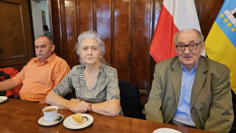 Trzy osoby siedzące przy stole: dwóch mężczyzn i kobieta