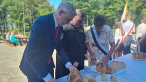 Krojenie chleba dożynkowego przez burmistrza MiG Pleszew, proboszcza parafii w Kuczkowie oraz starostów dożynek podczas dożynek parafialnych w Kuczkowie.
