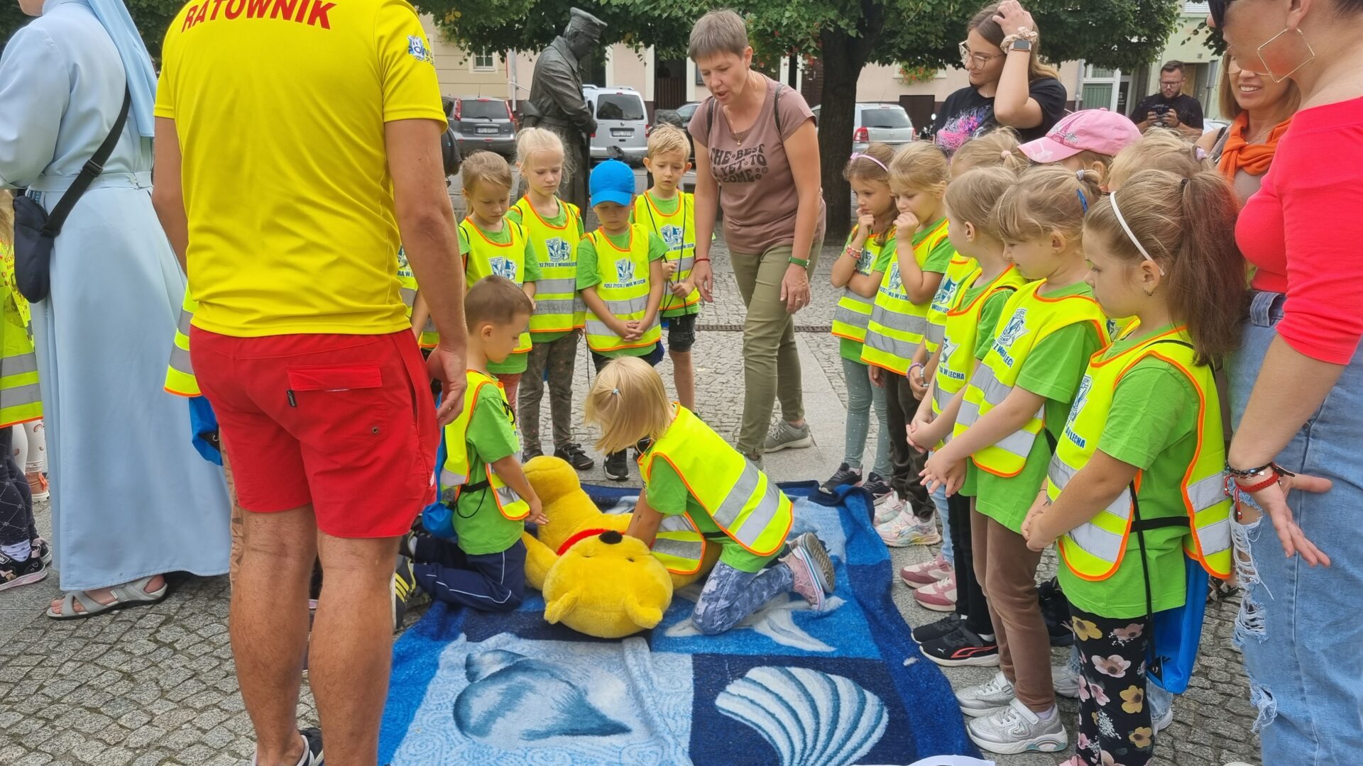 Najmłodsi przeprowadzający uciskanie na misiach w ramach akcji "Razem dla życia" organizowanej na pleszewskim rynku.