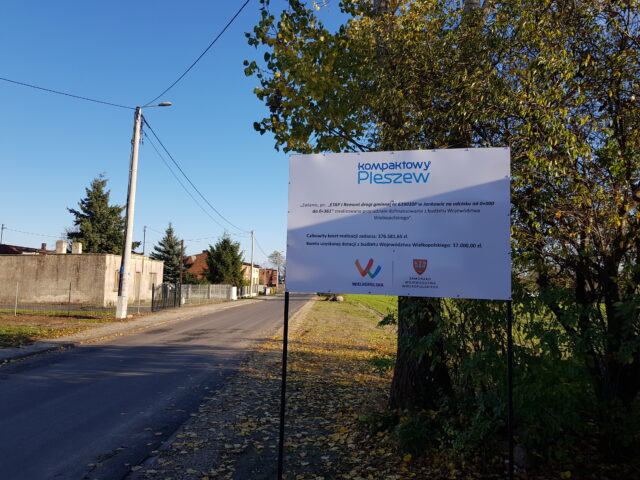 Wyremontowana droga w Jankowie w Gminie Pleszew i tablica przedstawiająca informacje o dofinansowaniu.