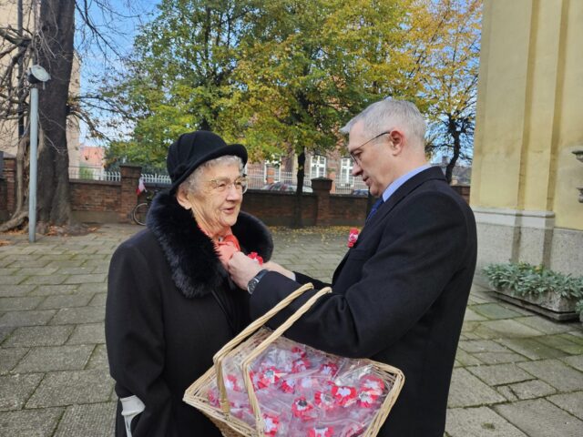 Wpinanie kotylionów przez burmistrza Pleszewa przed mszą św. z okazji rocznicy odzyskania przez Polskę niepodległości.