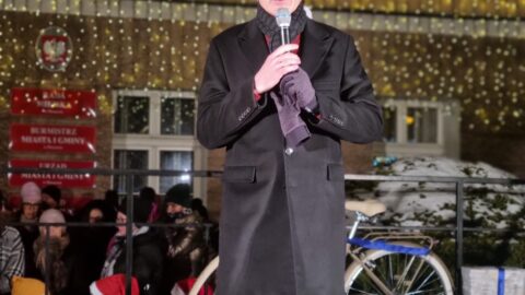 Burmistrz MiG Pleszew przemawiający na scenie przed ratuszem.