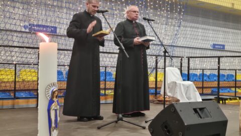 Księża wykonujący obrzęd wigilijny podczas wigilii dla samotnych w Pleszewie.