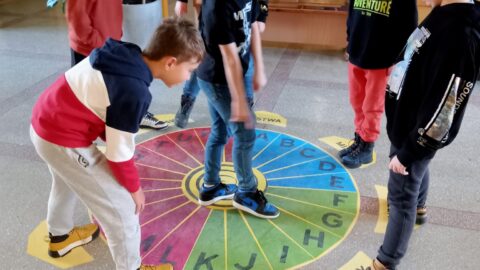 Dzieci grające na podłogowych grach w pleszewskiej szkole.