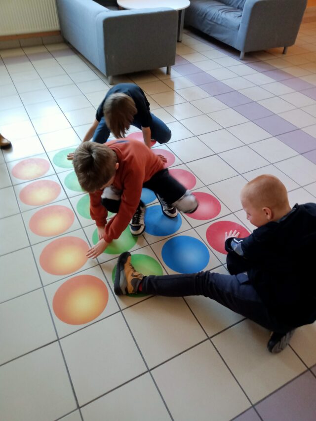 Dzieci grające na podłogowych grach w pleszewskiej szkole.