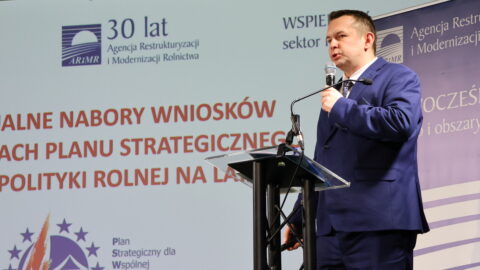 Osoba przemawiająca przy mównicy w Zajezdni Kultury w Pleszewie podczas Forum Rolniczego.