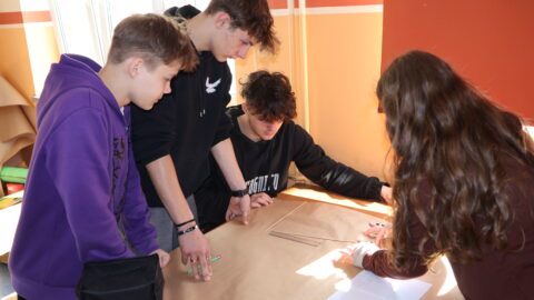 czwórka uczniów pracujących w grupie w sali lekcyjnej ZSP nr 1 w Pleszewie nad projektem w ramach Festiwalu Nauki.