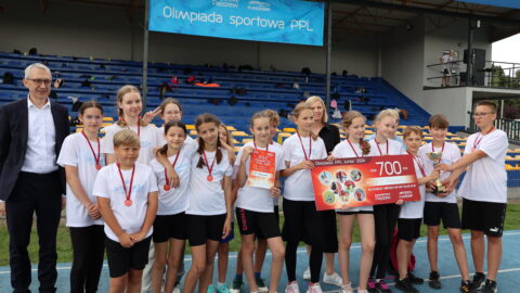 Laureaci I miejsca Olimpiady Sportowej PPL 2024 w klasach IV-VI z czekiem, pucharem i dyplomem.