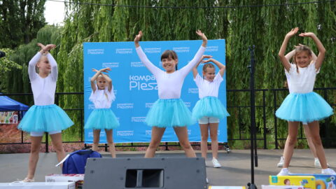 występy dzieci na scenie w parku miejskim podczas festynu.