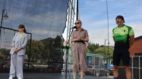 Wiceburmistrz Pleszewa stojąca na scenie Zajezdni Kultury w Pleszewie i przemawiająca przy ultrakolarzu i prowadzącej.