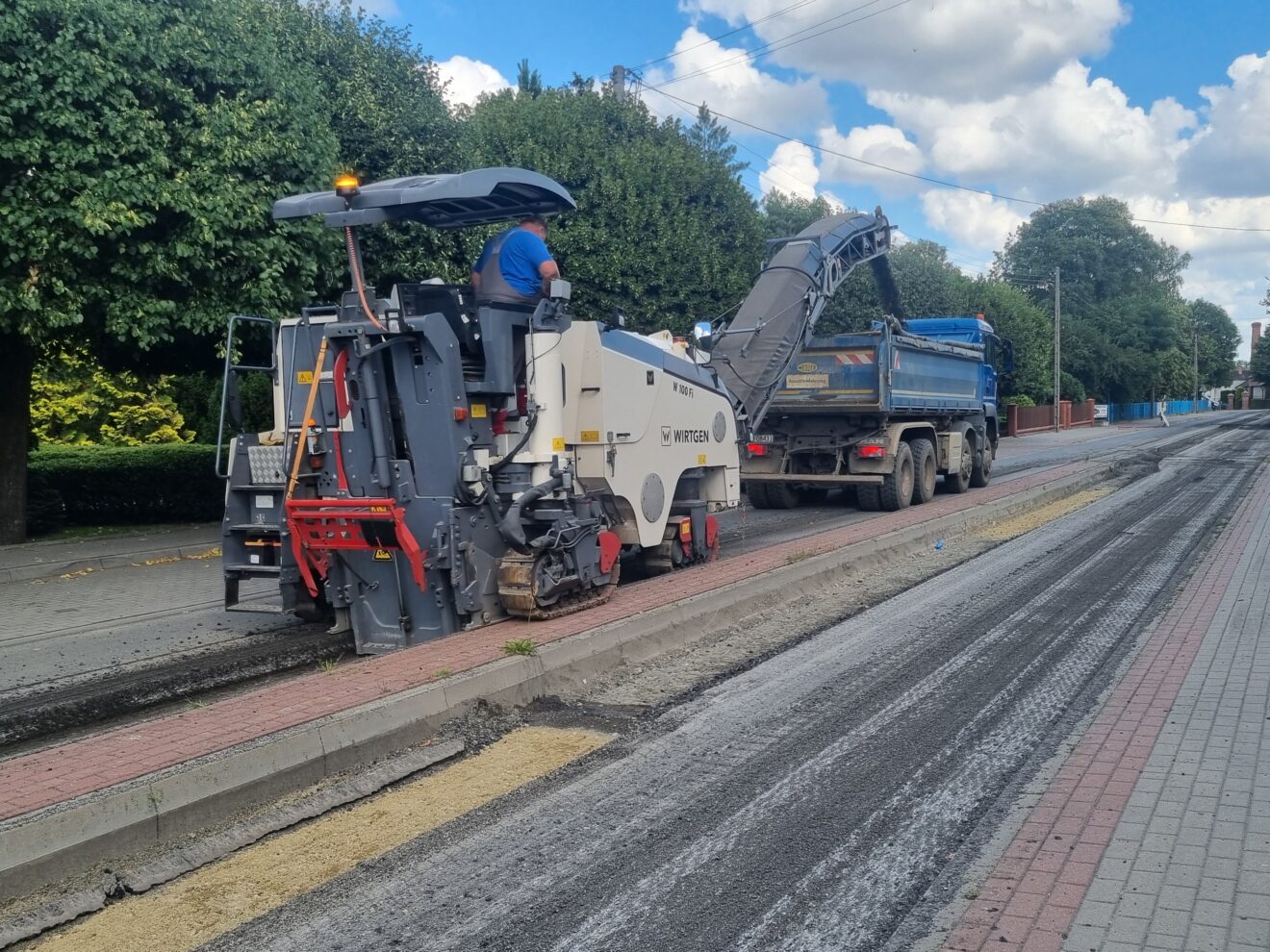 Ciężki sprzęt zrywający asfalt na ulicy B. Krzywoustego w Pleszewie.