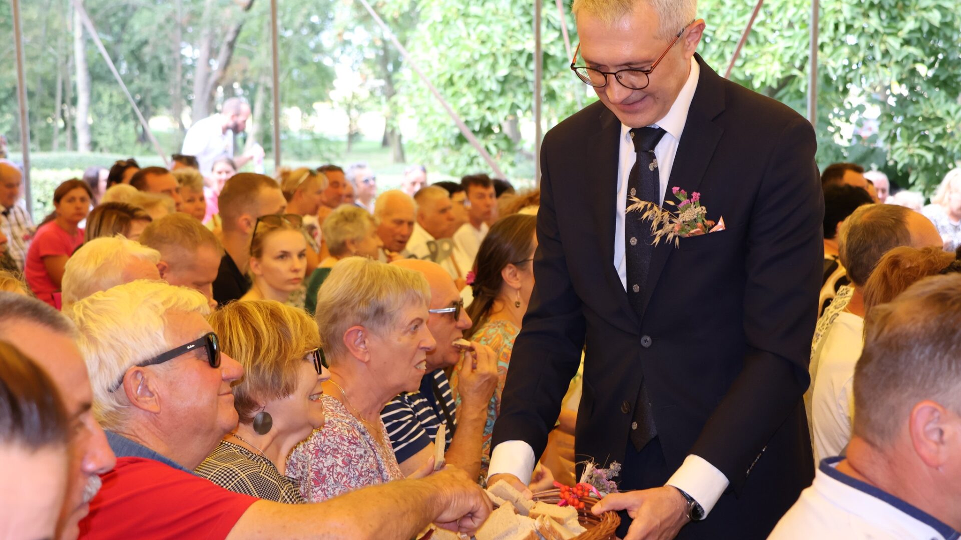 Rozdawanie chleba dożynkowego wśród gości przez burmistrza MiG Pleszew.