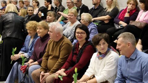 tłum osób siedzących w hali sportowej w oczekiwaniu na koncert