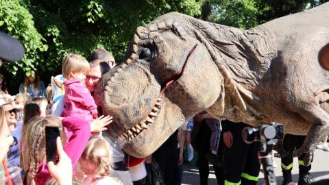 dinozaur przytulający się do malej dziewczynki i jej taty w parku miejskim w pleszewie.