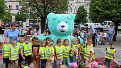 Dzieci z przedszkola stojące z wielkim pluszowym misiem