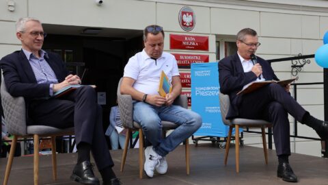 Mężczyźni czytający przed ratuszem dzieciom bajki