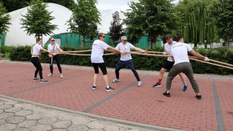 Przeciąganie samochodu w ramach Olimpiady Sportowej PPL na parkingu stadionu miejskiego