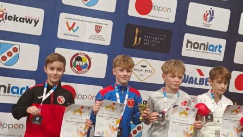 Chłopcy na podium zawodów karate z medalami i dyplomami