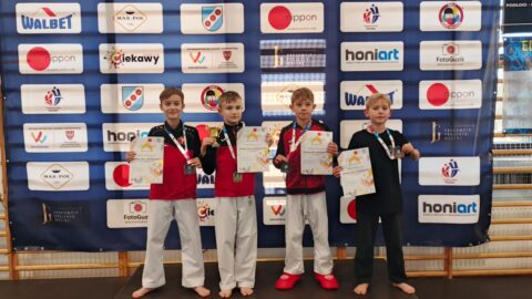Chłopcy na podium zawodów karate z medalami i dyplomami