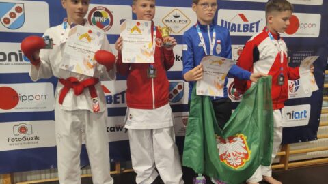Chłopcy na podium zawodów karate z medalami i dyplomami