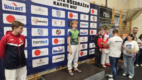 Chłopcy na podium zawodów karate z medalami i dyplomami