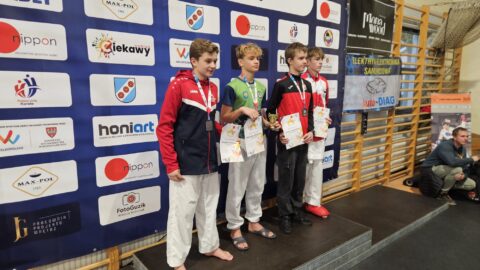 Chłopcy na podium zawodów karate z medalami i dyplomami