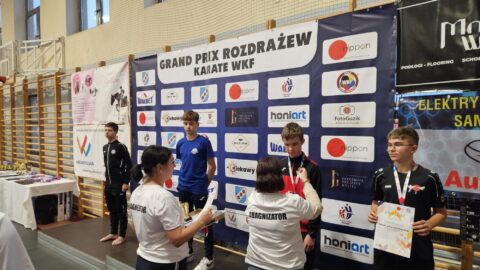 Chłopcy na podium zawodów karate z medalami i dyplomami