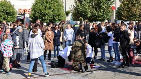 Dzieci, młodzież i dorośli ćwiczący resuscytację krążeniową na pleszewskim Rynku