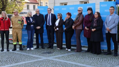 Osoby stojące przed budynkiem ratusza podczas akcji ćwiczenia resuscytacji krążeniowej.