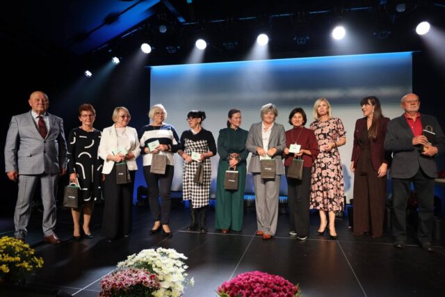 osoby stojące na scenie z wyróżnieniami z okazji 15-lecia Pleszewskiego UTW
