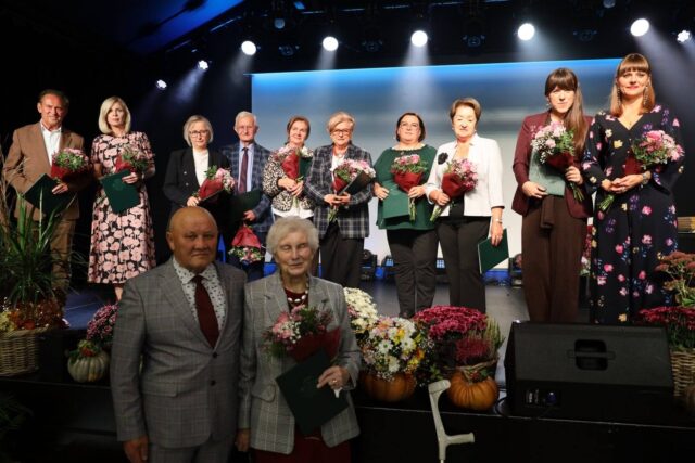 osoby stojące na scenie z wyróżnieniami z okazji 15-lecia Pleszewskiego UTW