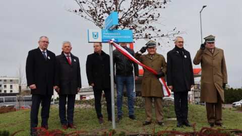 Władze oraz wojskowi odsłaniający tablicę z nową nazwą ronda w Pleszewie.