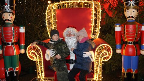 Dzieci z wizytą u św. Mikołaja siedzącego na tronie.