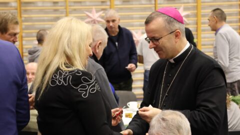 Dzielenie się opłatkiem na Wigilii dla Samotnych w Pleszewie.