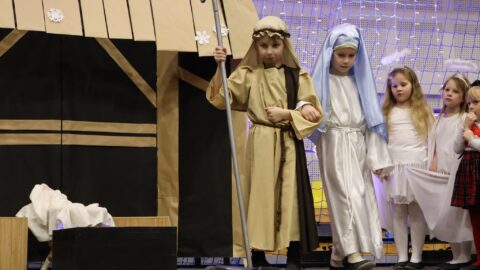 Przedszkolaki występujące na scenie w hali sportowej z jasełkami podczas Wigilii dla Samotnych w Pleszewie.