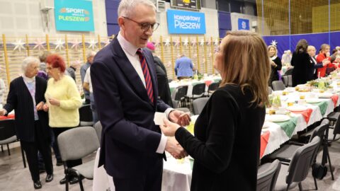 Dzielenie się opłatkiem na Wigilii dla Samotnych w Pleszewie.