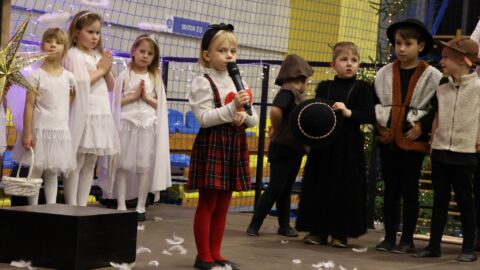 Przedszkolaki występujące na scenie w hali sportowej z jasełkami podczas Wigilii dla Samotnych w Pleszewie.