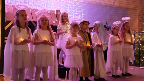 Przedszkolaki występujące na scenie w hali sportowej z jasełkami podczas Wigilii dla Samotnych w Pleszewie.