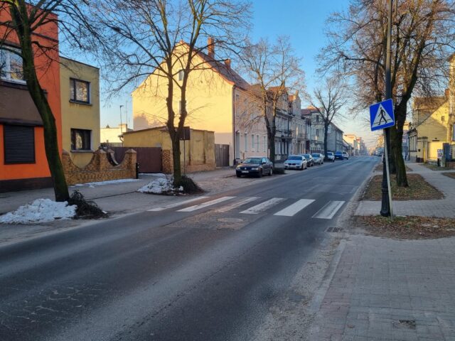 Przejście dla pieszych pomiędzy drzewami w mieście, które będzie przebudowane w SMART przejście.