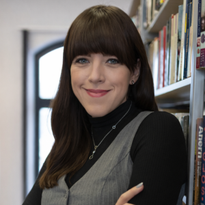 portret kobiety na tle regałów z książkami