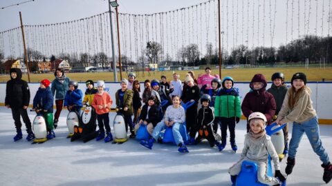 Łyżwiarze na mobilnej tafli pleszewskiego lodowiska na stadionie miejskim podczas grupowej jazdy.